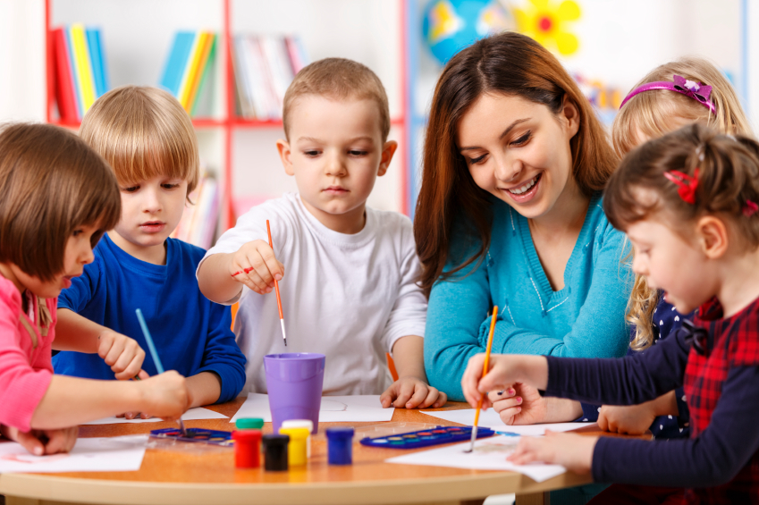 Docente acompañando una actividad creativa con niñas y niños